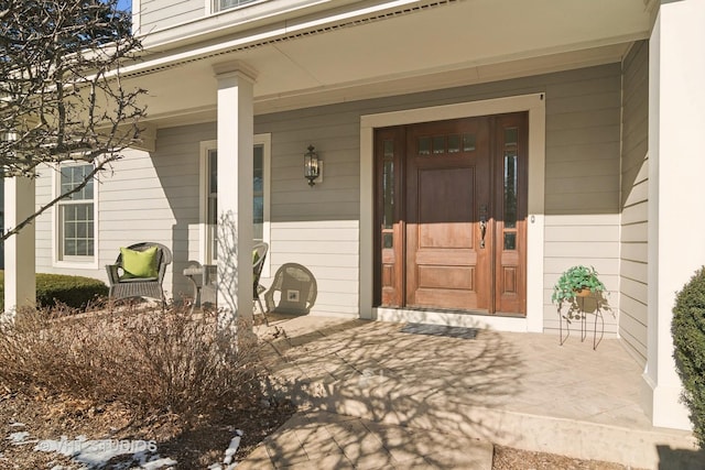 view of exterior entry featuring covered porch