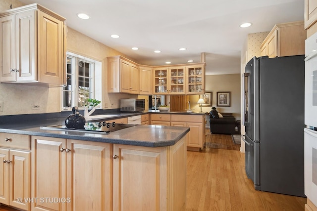 kitchen featuring stainless steel refrigerator, black electric stovetop, kitchen peninsula, light brown cabinetry, and light hardwood / wood-style flooring