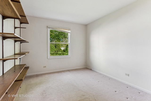 empty room featuring baseboards and carpet floors