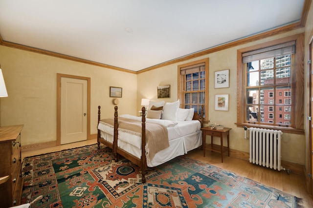 bedroom featuring crown molding, radiator heating unit, and hardwood / wood-style floors