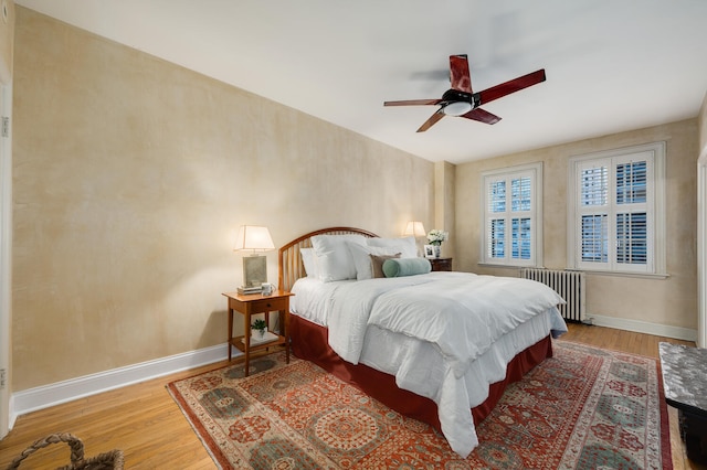 bedroom featuring hardwood / wood-style flooring, ceiling fan, and radiator heating unit