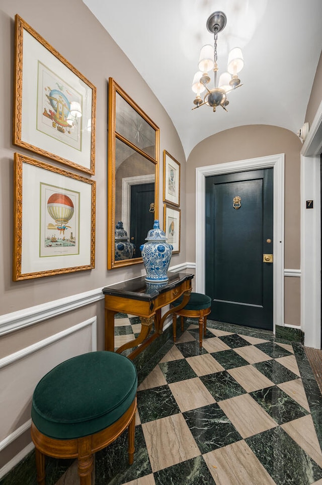 foyer entrance with vaulted ceiling and a notable chandelier