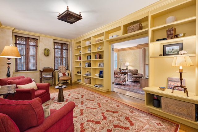 living area with built in features, wood-type flooring, and ornamental molding