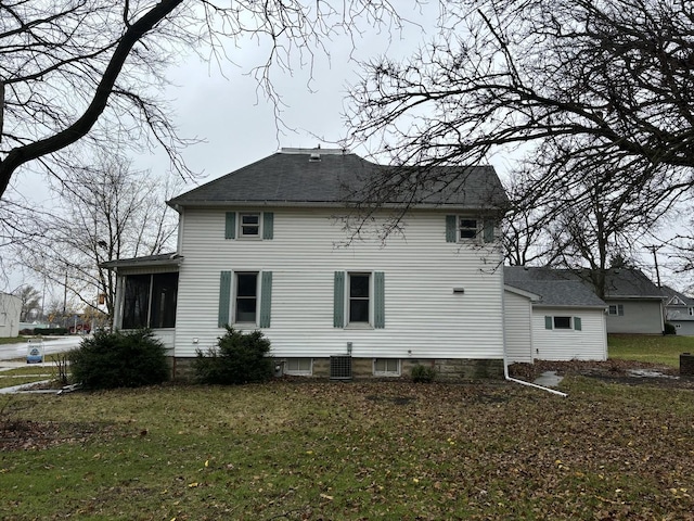 back of property featuring central AC unit, a sunroom, and a yard