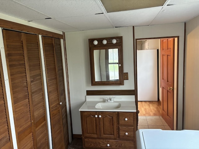 bathroom with vanity, a paneled ceiling, and tile patterned flooring