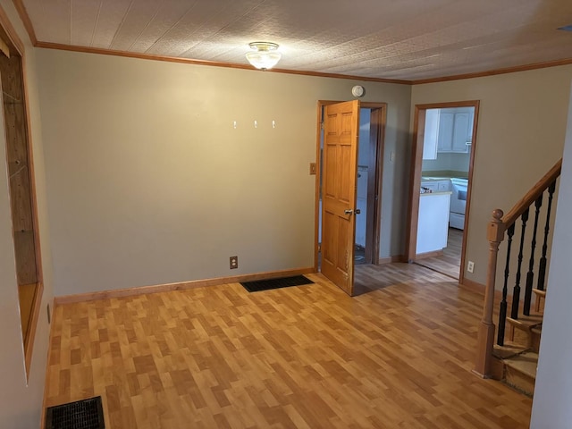 empty room featuring light hardwood / wood-style floors and crown molding