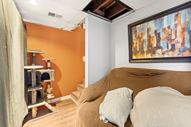 bedroom featuring a paneled ceiling and hardwood / wood-style flooring