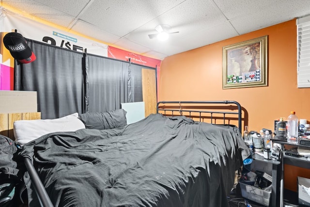 bedroom featuring ceiling fan and a drop ceiling