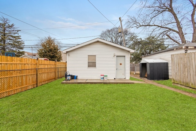 back of property with a storage shed and a yard