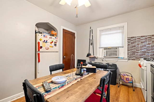 dining space featuring light wood-type flooring, cooling unit, and ceiling fan