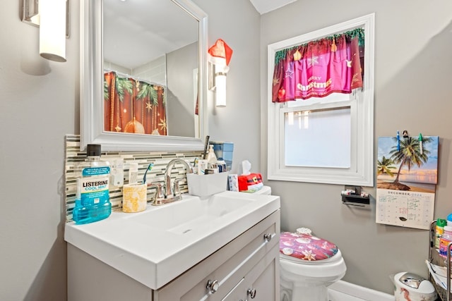 bathroom with vanity, backsplash, and toilet