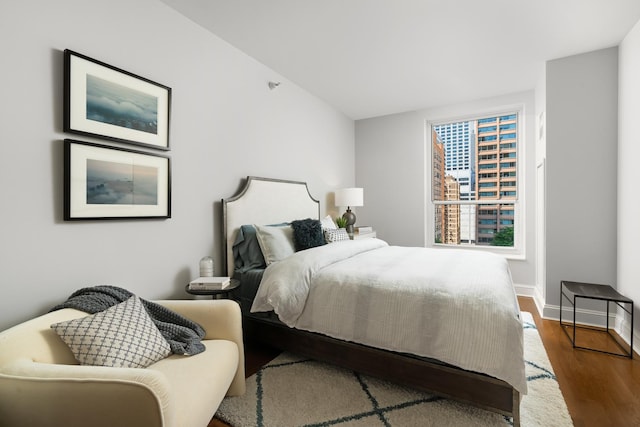 bedroom featuring dark wood-style flooring and baseboards