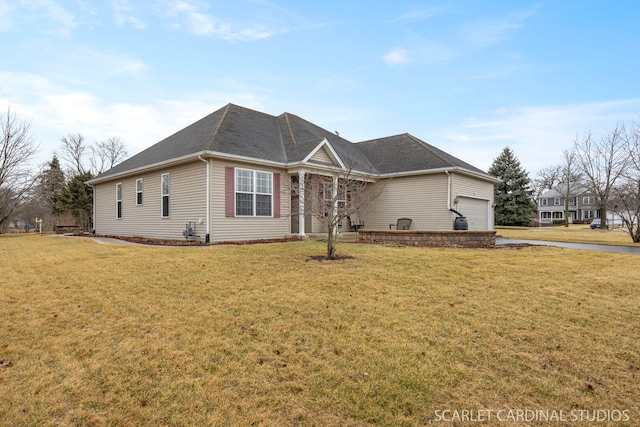 view of front of house featuring a shingled roof, a front yard, and an attached garage