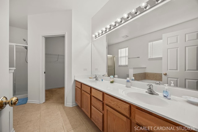 full bath featuring a garden tub, tile patterned floors, a sink, and a shower stall