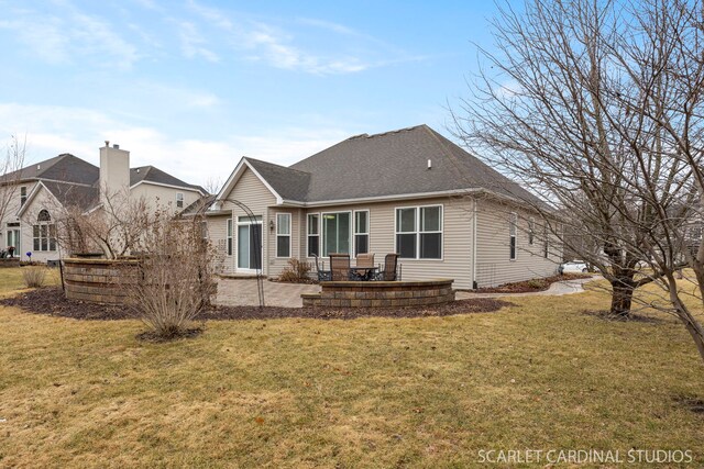 back of property with roof with shingles, a lawn, and a patio area