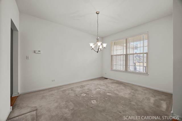 empty room featuring baseboards, carpet floors, and a notable chandelier