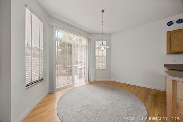 dining space featuring light wood-type flooring and baseboards