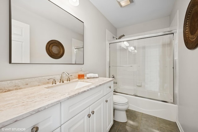 full bathroom with toilet, tile patterned floors, vanity, and shower / bath combination with glass door