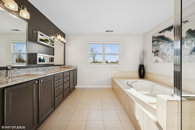 bathroom featuring tile patterned floors, a relaxing tiled tub, and vanity