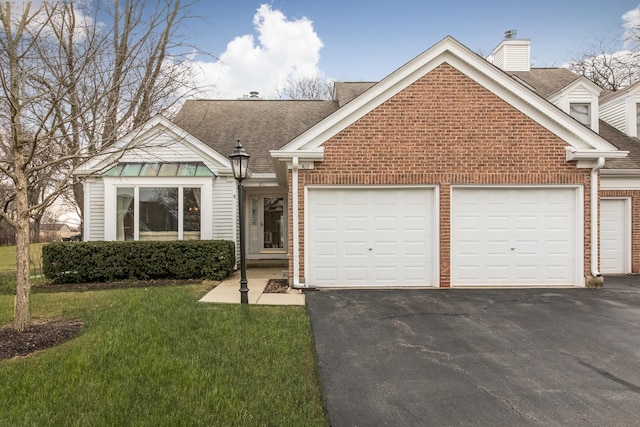 view of front of property with aphalt driveway, brick siding, a shingled roof, a front yard, and a garage