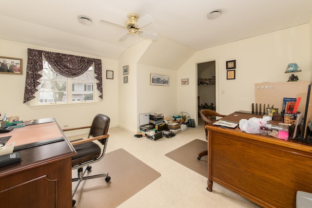 carpeted office space featuring vaulted ceiling and a ceiling fan