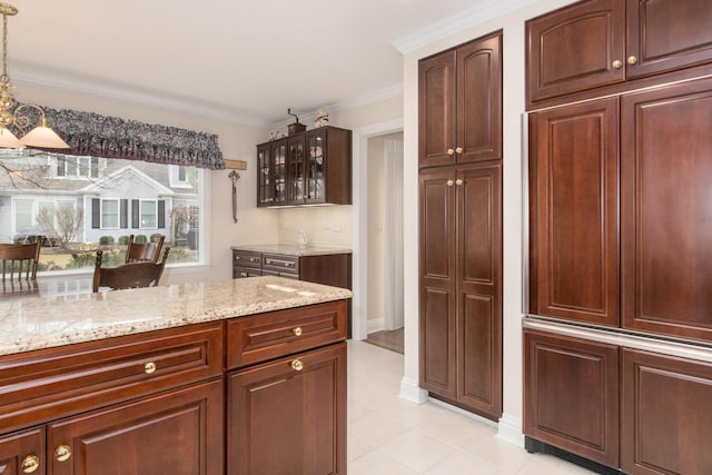 kitchen with glass insert cabinets, light stone counters, and ornamental molding