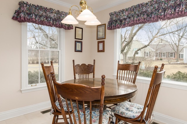 dining area with ornamental molding, tile patterned floors, visible vents, and baseboards