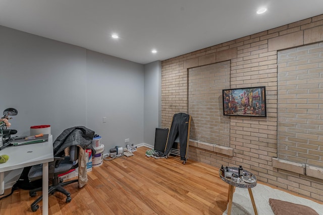 office with brick wall and wood-type flooring