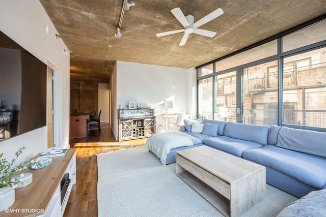 living room featuring wood-type flooring, a wall of windows, and ceiling fan