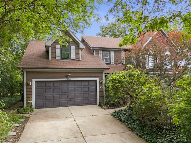 view of front facade featuring concrete driveway and a shingled roof