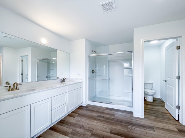 bathroom with toilet, an enclosed shower, and hardwood / wood-style flooring