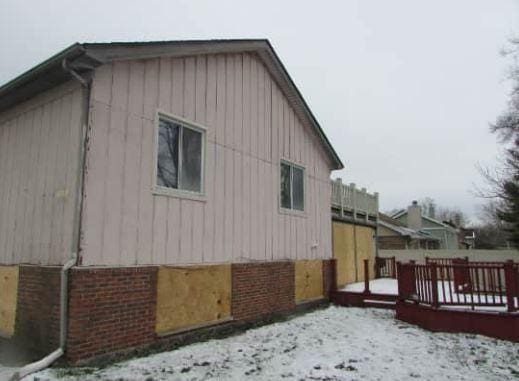 view of snow covered exterior with a wooden deck