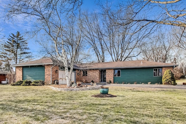 view of front facade with an attached garage, brick siding, and a front yard