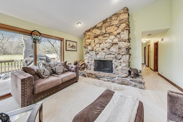 living room featuring a fireplace, light wood-type flooring, and high vaulted ceiling