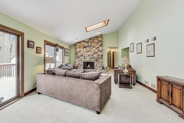 carpeted dining area with a chandelier, high vaulted ceiling, and a skylight