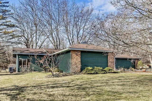 view of side of property featuring a lawn and central air condition unit