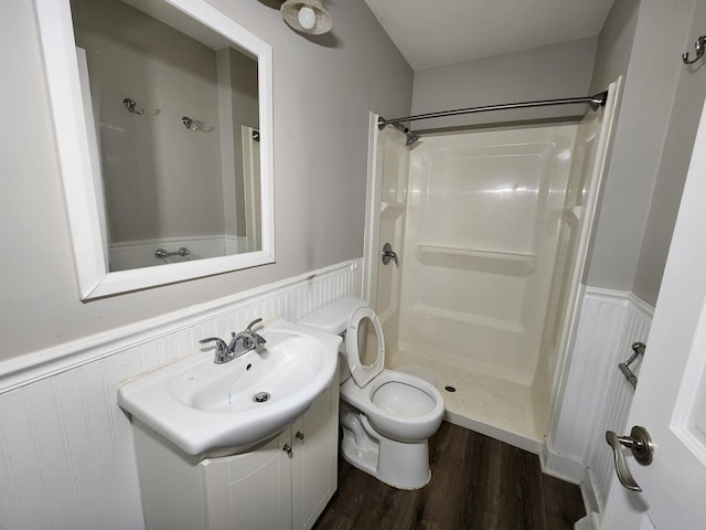 bathroom with a shower, hardwood / wood-style floors, vanity, and toilet