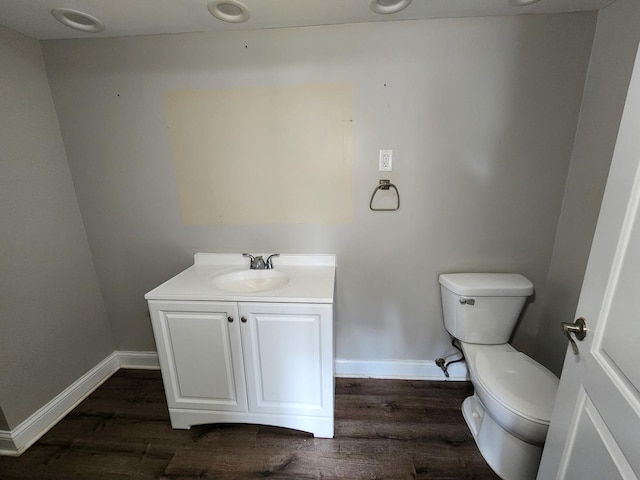 bathroom with hardwood / wood-style floors, vanity, and toilet