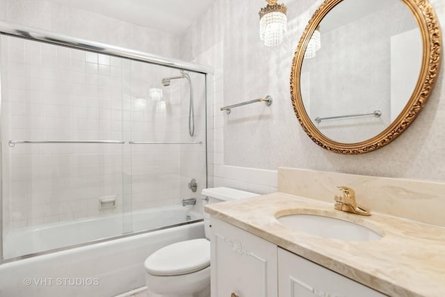 full bathroom with shower / bath combination with glass door, vanity, and toilet