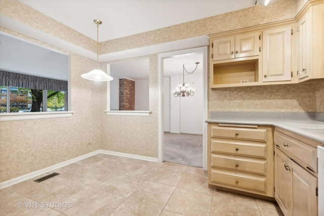 kitchen featuring hanging light fixtures, a notable chandelier, light tile patterned floors, and dishwasher