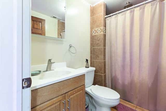 bathroom featuring vanity, toilet, and curtained shower