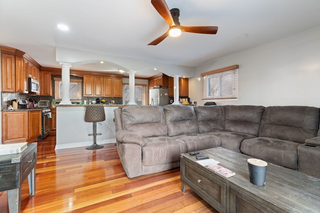 living room with light hardwood / wood-style flooring and ceiling fan