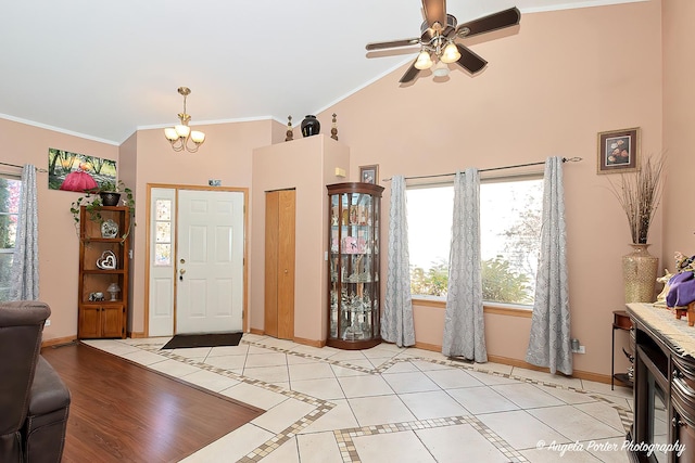 tiled entrance foyer featuring ceiling fan with notable chandelier and ornamental molding