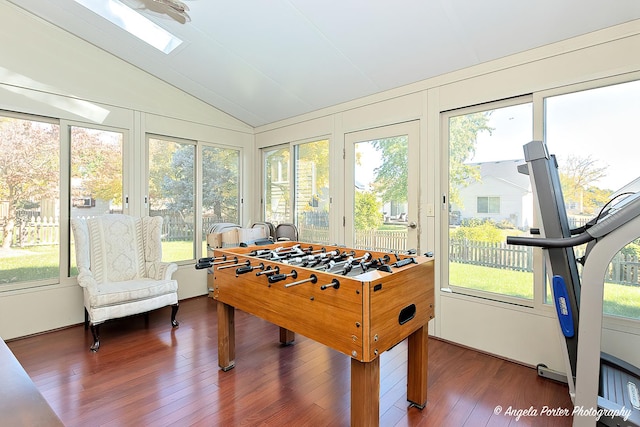 game room featuring dark wood-type flooring and vaulted ceiling with skylight