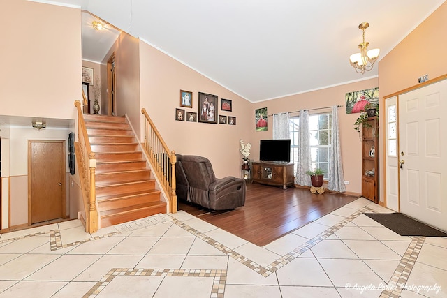 tiled entryway with crown molding and a chandelier