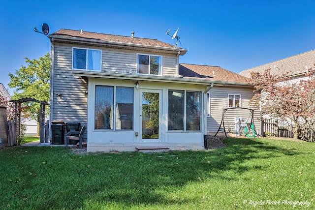 back of property featuring a yard and a sunroom