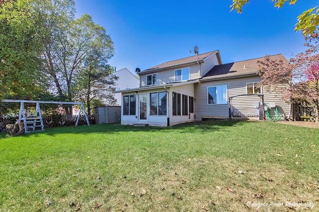 rear view of house with a lawn, a storage unit, and a sunroom