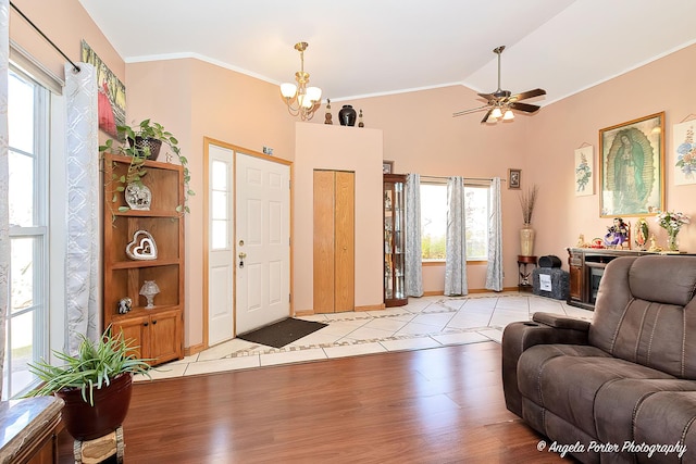 tiled entrance foyer featuring ceiling fan with notable chandelier, plenty of natural light, and lofted ceiling