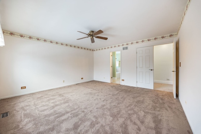 unfurnished bedroom with ceiling fan, light colored carpet, and ensuite bathroom