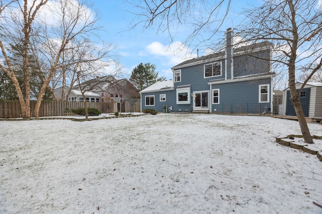 snow covered house with a storage unit